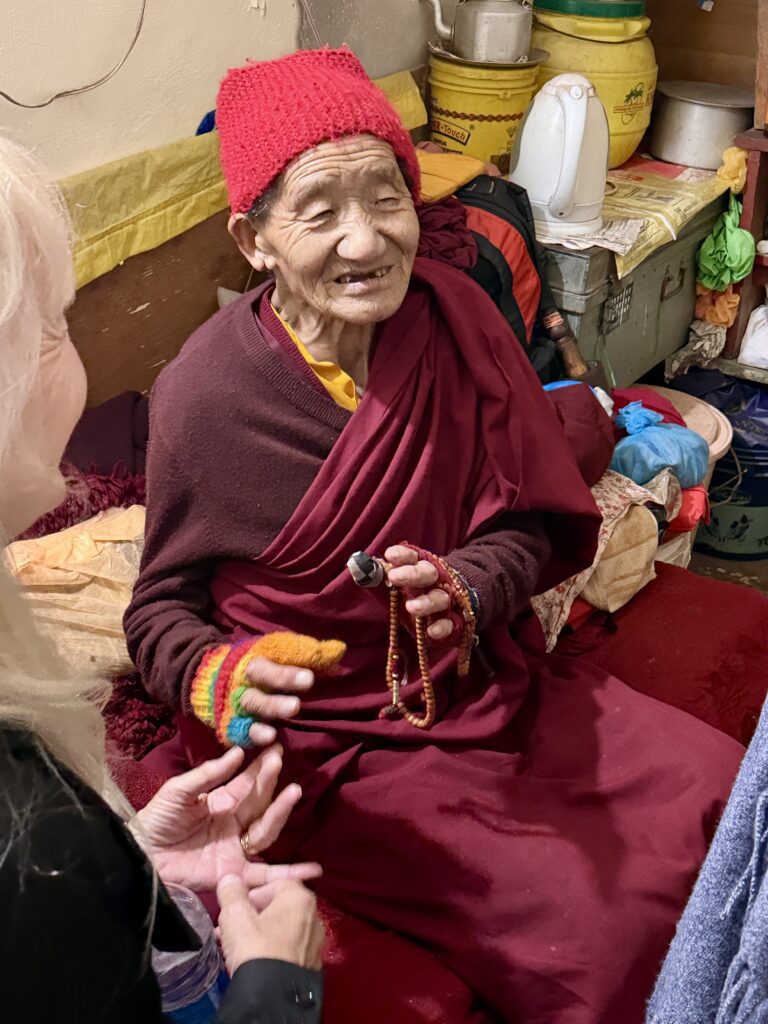 Older woman wearing a red knitted cap and a burgundy shawl